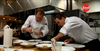 Jonathan Goodyear (left) and Dan Hudson wipe down plates for Nicole Gomes. Courtesy Food Network Canada.