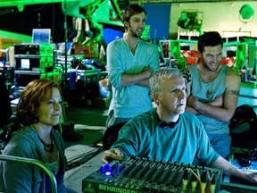 On the set of Avatar, writer-director James Cameron (front, centre) reviews a scene with actors Sigourney Weaver (left), Joel David Moore and Sam Worthington.
