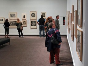 Visitors take in the M.C. Escher: The Mathemagician exhibit at the Glenbow Museum.