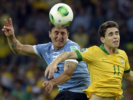 Uruguay's midfielder Cristian Rodriguez (L) and Brazil's forward Oscar jump for a header during their FIFA Confederations Cup Brazil 2013 semifinal football match, at the Mineirao Stadium in Belo Horizonte on June 26, 2013.  AFP PHOTO / DANIEL GARCIADANIEL GARCIA/AFP/Getty Images 