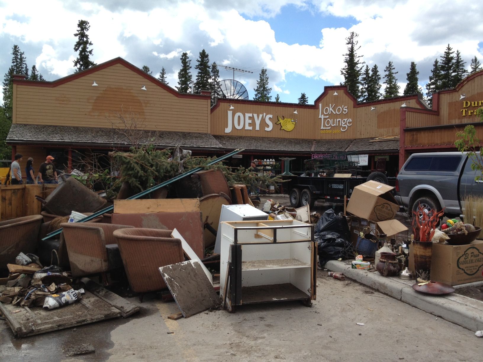 Flood debris and ruined restaurant chairs are piled up in a parking lot in Bragg Creek. (Michele Jarvie/Calgary Herald)