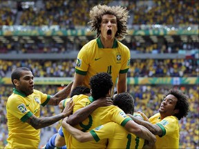 David Luiz of Brazil celebrates after Neymar scored his team's opening goal during the FIFA Confederations Cup Brazil 2013 Group A match between Brazil and Japan at National Stadium on June 15, 2013 in Brasilia, Brazil.  (Photo by Dean Mouhtaropoulos/Getty Images)