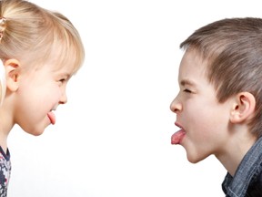 Children sticking out tongues