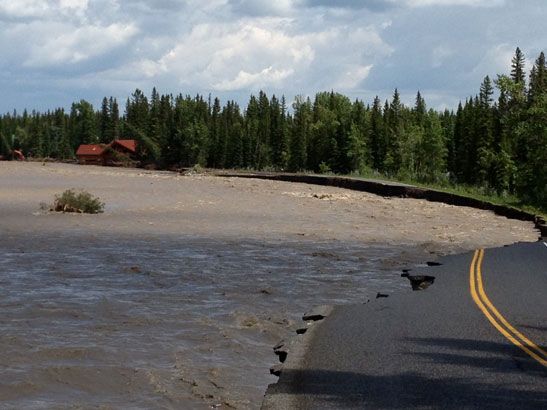 Highway 758 southwest of Bragg Creek is washed out by the Elbow River. The Bragg Creek Trading Post, a local landmark, can be seen in the background, severely damaged. (Michele Jarvie/Calgary Herald)