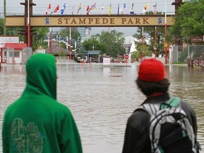The Grounds at the Calgary Stampede are covered in water. A pedestrian bridge on the site has been washed away by the Elbow River.