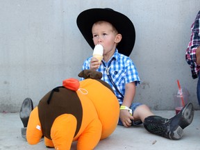 Calgary's Nolan Savard beats the heat with ice cream as he visited the grounds with his babysitter during BMO Kids day at the Calgary Stampede on July 10.