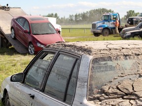 A muck-covered car recovered from High River sits in a field as work continues in the town in late June.