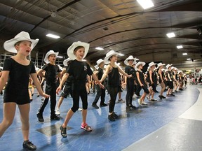 A line of Young Canadians prepares for the big finale during a practice run of the TransAlta Grandstand Show for this year's Stampede.