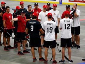 Head coach Mike Babcock, fourth from left, from Saskatoon, Sask., goes over a drill with players during a ball hockey training session at the Canadian national men's team orientation camp in Calgary.