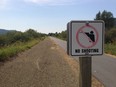 Signs warn hunters not to fire near the Trail of the Coeur d'Alenes bike route in northern Idaho.