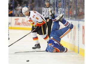 Jesse Joensuu of the Edmonton Oilers is sent flying by Dennis Wideman of the Calgary Flames at Rexall Place in Edmonton.
