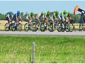 Part of the main pack of cyclists on highway 833 pass a pump jack just about 10 km north of Camrose during the first stage of the Tour of Alberta, professional cycling race from Sherwood Park to Camrose, September 4, 2013.