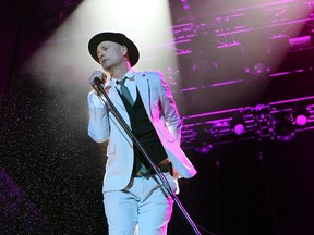 The Tragically Hip lead singer Gord Downie performs to a soaked crowd during a concert at Shaw Millennium Park on Saturday.