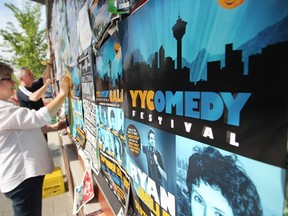 Harry Doupe and Cory Mack, two of the three producers of the YYComedy Festival, put up posters at the Sunnyside LRT station poster wall. The second-annual festival goes Monday through Sunday.