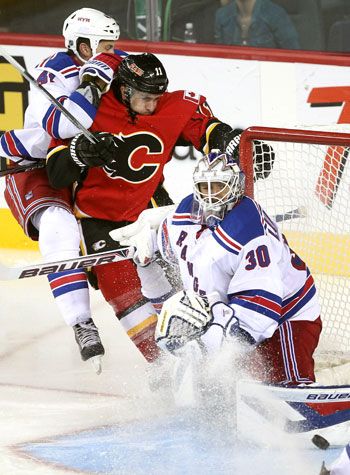 Calgary Flames centre Mikael Backlund fought for the puck against New York Rangers defenceman Stu Bickel. Coach Bob Hartley hopes Backlund will take note of the Detroit Red Wings’ offense for some pointers on three-zone play.