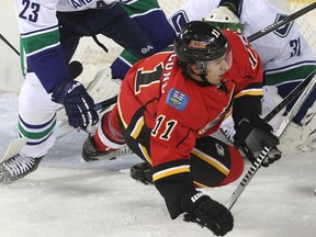 Calgary Flames centre Mikael Backlund was sent crashing to the ice by Vancouver Canucks defenceman Alexander Edler outside the Canucks crease during first period NHL action of the Flames season home opener at the Scotiabank Saddledome on October 6, 2013.