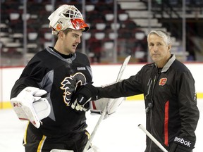 Goaltender Reto Berra talks with Coach Bob Hartley.