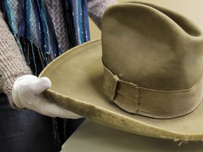 Sarah Little, collections manager, holds up Guy Weadick's hat, seven months after the Highwood River flooded, parts of the Museum of the Highwood Collection are starting to be returned to a storage site in High River.