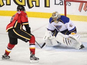 Calgary  Flames Joe Colborne, left, scores in OT on St. Louis Blues goalie Jaroslav Halak during their game at the Scotiabank Saddledome on December 23, 2013. (Leah Hennel/Calgary Herald)
