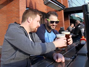 Andrew Bullied, left, and Jeremy McLaughlin share a toast on the patio of the National on Jan. 17. All that's missing is a couple of Bingo cards.