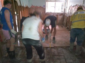 Hayley Wickenheiser snapped this photo of fellow volunteers stripping hardwood in a flooded Elbow Park Home, June 29. Twitter.com