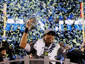 Quarterback Russell Wilson #3 of the Seattle Seahawks celebrates with the Vince Lombardi Trophy after their 43-8 victory over the Denver Broncos during Super Bowl XLVIII at MetLife Stadium on February 2, 2014 in East Rutherford, New Jersey.  A record number of Calgarians watched the game.
