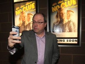 Ted Rhodes, Calgary Herald
 Comedian Brent Butt takes a selfie in front of the posters for his new movie No Clue during a screening at the Chinook Centre Cinemas Monday night.  00053181A