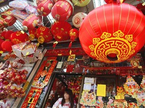 A woman walks out a shop selling seasonal items for Chinese New Year in Chinatown in Bangkok, Thailand. Herald wire services; AP Photo.