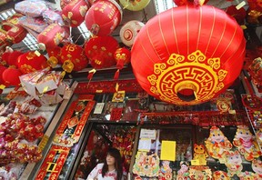 A woman walks out a shop selling seasonal items for Chinese New Year in Chinatown in Bangkok, Thailand. Herald wire services; AP Photo.