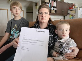 Kendra Lindon with her sons, from left, Cameron and Cody, holds an employment termination notification from First Student Canada.