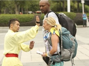 Mark, far right, and Mallory receive directions via a stamp on their forehead on The Amazing Race All-Stars.