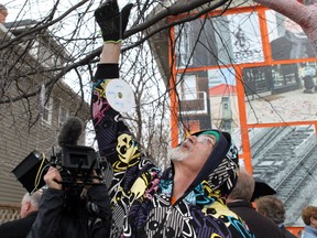 An artist known as Bill adds CDs with messages on them to decorate a tree in front of a rooming house which will be torn down in June to make way for an apartment building that will provide permanent housing for homeless people. Stepping Stone Manor at 222 15th Ave. S.W. will be home to 30 residents when it's finished.