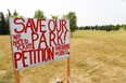 A petition sign stands in a park that is slated for a francophone school in Scenic Acres. Some residents are opposed to a school being built on the side because it will take up some of the current park space.