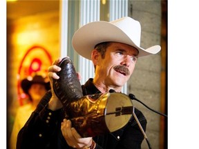 The 2013 Calgary Stampede Parade Marshal Chris Hadfield shows off his cowboy boots while speaking to the media at the official Stampede Store on Thursday, July 4, 2013.