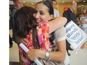 Albina Shuman is hugged by a friend after speaking about her daughter, who is currently serving with the Israeli military, at the Calgary Jewish Federation.