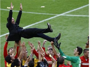 Atletico Madrid’s coach Diego Simeone gets lifted by the team as it celebrates the Spanish league title at the end a week ago. Atletico Madrid claimed their 10th Spanish league crown, and now can claim the Champions League title as well.