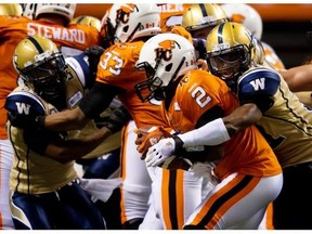 Blue Bombers defender Maurice Leggett, right, sacks B.C. Lions quarterback Kevin Glenn during a Winnipeg win Friday in Vancouver. Glenn has been under pressure in his first season with the Lions.