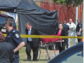 The body of the man shot by police Sunday night is removed from the scene as police continue to investigate the area.