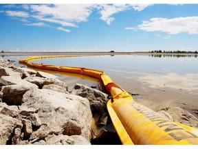 A boom stretches out to contain the Rangeland Pipeline leak on Gleniffer reservoir in June 2012. The pipeline owner, Plains Midstream, has been charged.