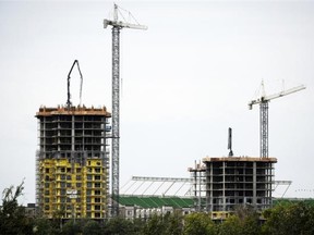 New buildings rise in front of Commonwealth Stadium in Edmonton. Analysts say Edmonton’s rapid growth has been helped by its housing affordability edge and the availability of service jobs in the oilpatch.