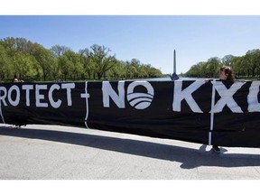 The Washington Monument backdrops a protest banner against the proposed Keystone XL oil pipeline Thursday, April 24, 2014, in Washington. The Keystone XL pipeline may be stalled but it's pumping a steady flow of cash into Washington, where inertia is a multibillion-dollar industry. THE CANADIAN PRESS/AP, Manuel Balce Ceneta