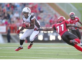 Calgary Stampeders defender Joshua Bell, right, tackles  Ottawa RedBlacks Chevon Walker during their game at McMahon Stadium in Calgary on Aug. 9.
