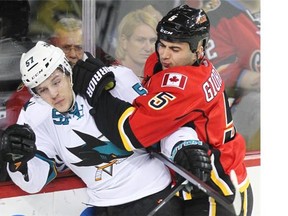 Calgary Flames captain Mark Giordano hits San Jose’s Tommy Wingels during a game last season. The Flames will kick off their regular season on Oct. 8 vs. Vancouver. As for the Sharks, they will visit on February 4, 2015.