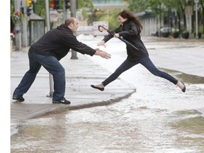 Calgary Herald photojournalist Leah Hennel won a National Newspaper Award in the feature photo category for this image of a woman leaping over a huge puddle into the arms of her husband during the June flood.