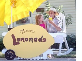 Calgary’s Madison Yaworski-Boucher, 8, sat with her grandfather Robin Webster at the Marda Loop lemonade stand the two built. Yaworski-Boucher and some friends were selling lemonade to passersby to beat the summer heat on Tuesday.