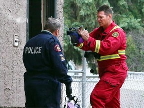Calgary Police and fire inspect the scene of a fatal fire at a Forest Lawn home on Sunday.