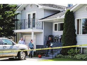 Calgary police investigators check out the home on Wednesday from where five-year-old Nathan O'Brien and his grandparents Alvin and Kathryn Liknes disappeared.