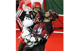 Calgary Roughnecks defenceman Curtis Manning, left, hassles Colorado Mammoth forward John Grant Jr. during a game last season.