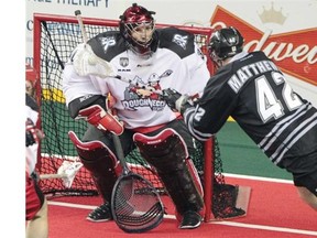Calgary Roughnecks goalie Mike Poulin, left, defends the net against an effort by the Edmonton Rush’s Mark Matthews during the first quarter of their NLL west final playoff game at the Scotiabank Saddledome last Saturday. Matthews later scored what he thought was the OT winner only to have it called back because he was in the crese.