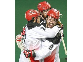 Calgary Roughnecks Karsen Leung, left, and Garrett McIntosh celebrate after Shawn Evans scored the winning goal in overtime to defeat the Colorado Mammoth in the opening game of the National Lacrosse League playoffs.
